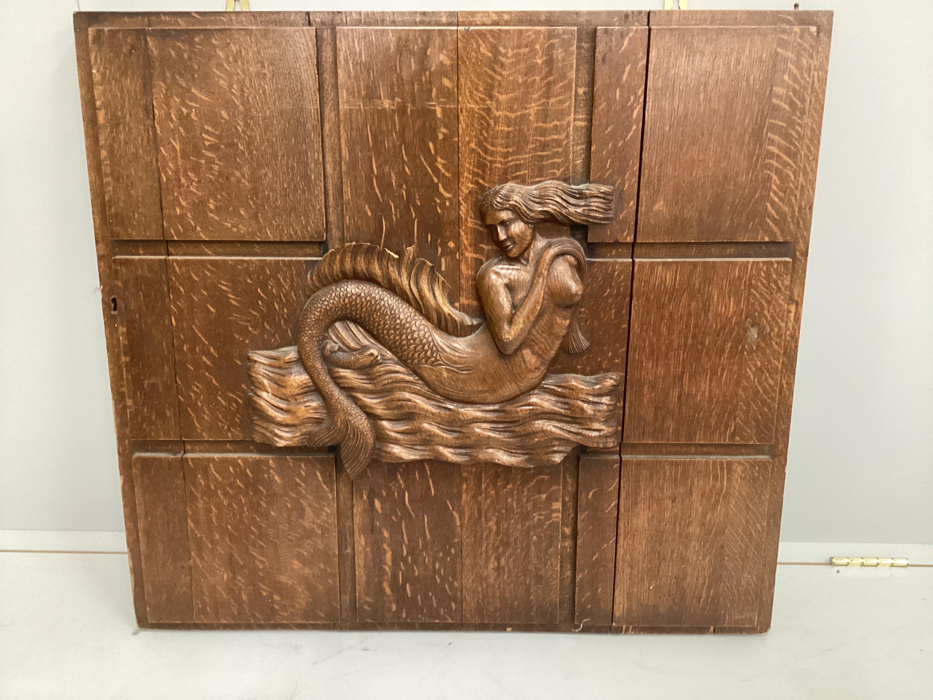 A rectangular carved oak mermaid plaque (formerly a cabinet door), width 81cm, height 75cm